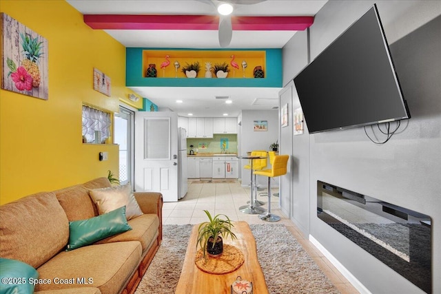 living room with light tile patterned floors, beam ceiling, and sink