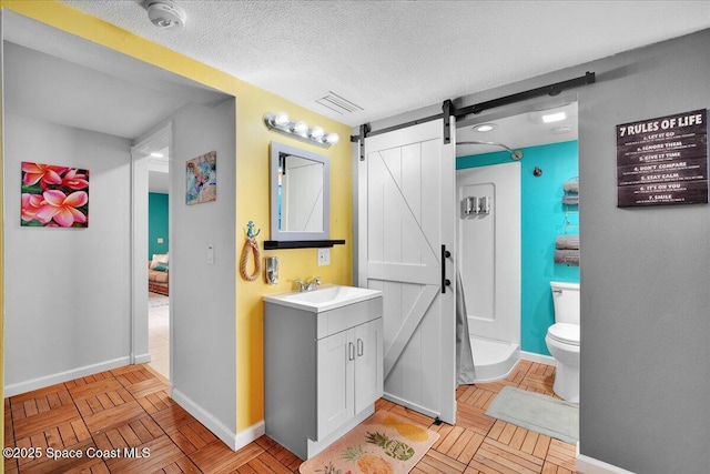 bathroom featuring parquet flooring, vanity, toilet, and a textured ceiling