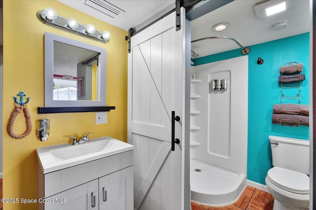 bathroom with walk in shower, vanity, toilet, and parquet floors