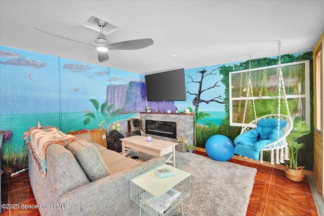 living room with ceiling fan, a fireplace, and dark parquet floors