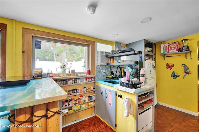 kitchen with sink and dark parquet flooring