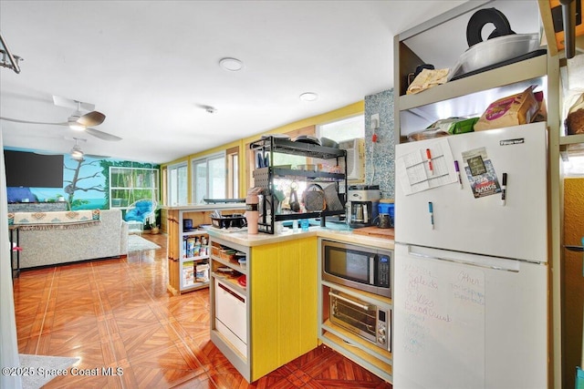 kitchen featuring white fridge, parquet floors, and ceiling fan