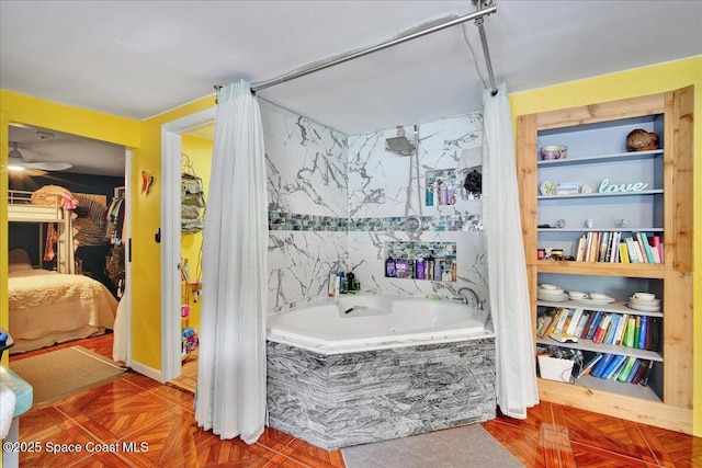 bathroom featuring built in shelves, parquet flooring, and tiled bath