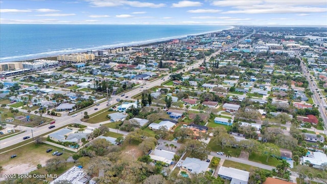 birds eye view of property with a water view and a beach view