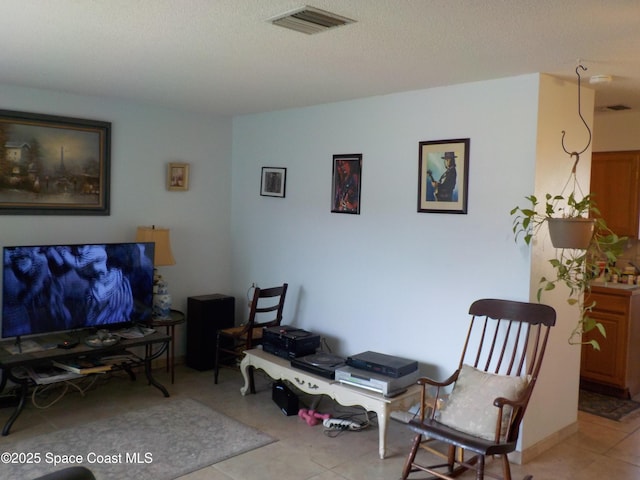 living area with light tile patterned flooring and a textured ceiling