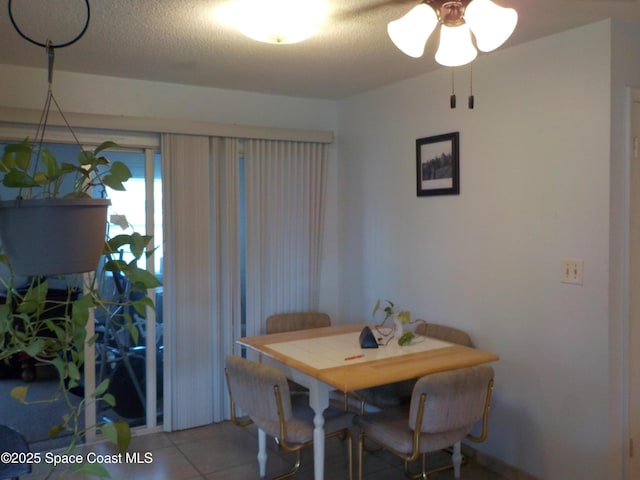 dining space featuring tile patterned floors and a textured ceiling