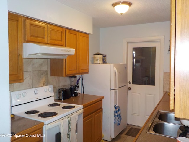 kitchen with white appliances, sink, and backsplash