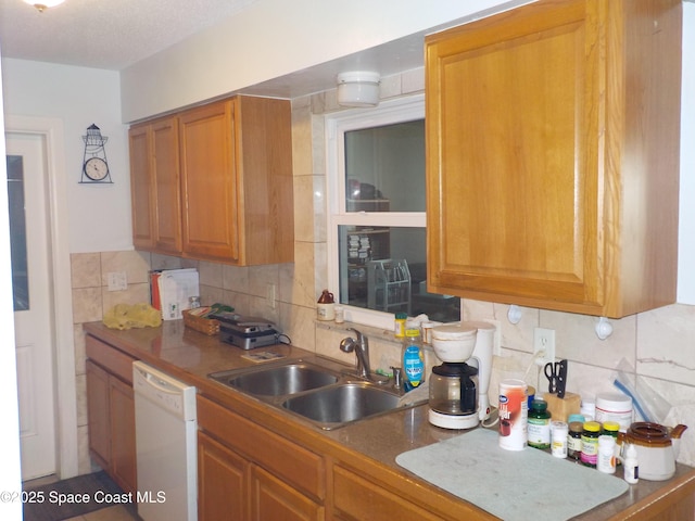 kitchen featuring sink, backsplash, and white dishwasher