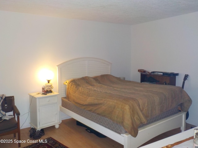 bedroom with hardwood / wood-style flooring and a textured ceiling