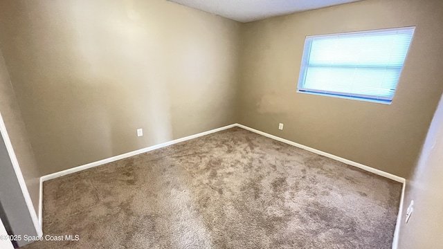 carpeted spare room with baseboards