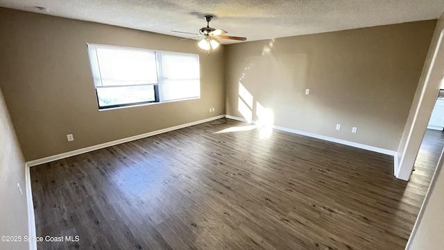 unfurnished room featuring a textured ceiling, ceiling fan, dark wood finished floors, and baseboards