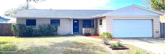 ranch-style home with brick siding, an attached garage, a front yard, fence, and driveway