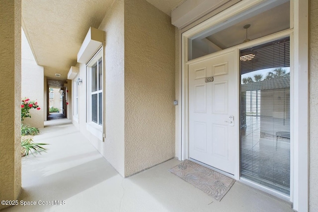 doorway to property featuring stucco siding