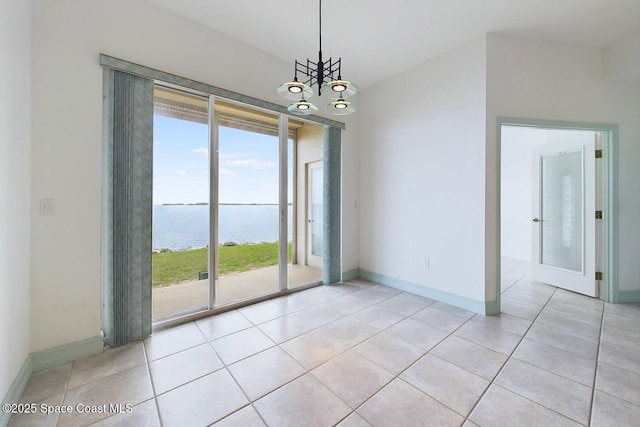 empty room featuring a water view, light tile patterned floors, baseboards, and a chandelier