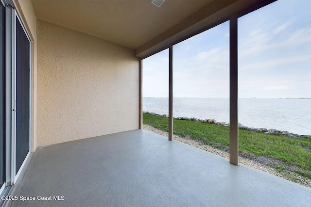 unfurnished sunroom featuring a water view