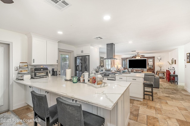 230 Andros Dr, Merritt Island, FL 32952 - kitchen with appliances with stainless steel finishes, island range hood, a kitchen breakfast bar, and white cabinets