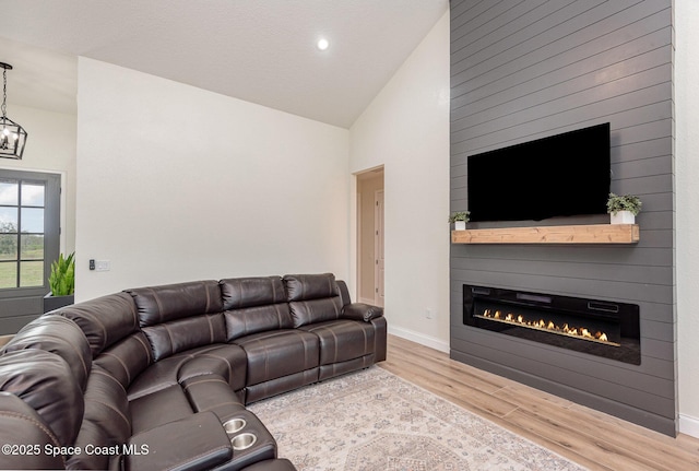 living room with a fireplace, wood-type flooring, and vaulted ceiling