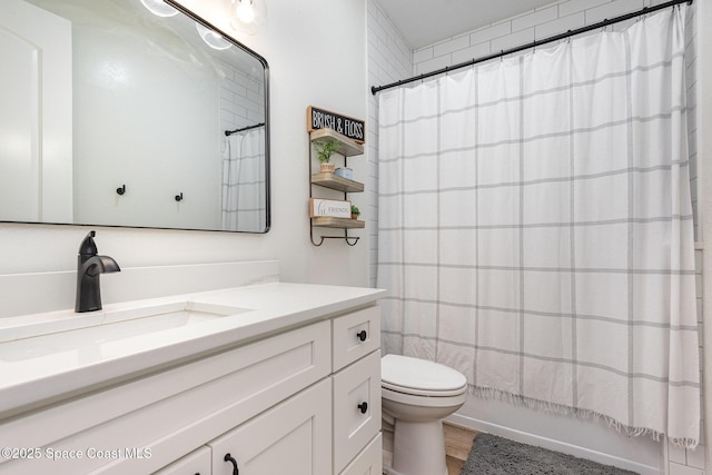 full bathroom with vanity, shower / tub combo, and toilet