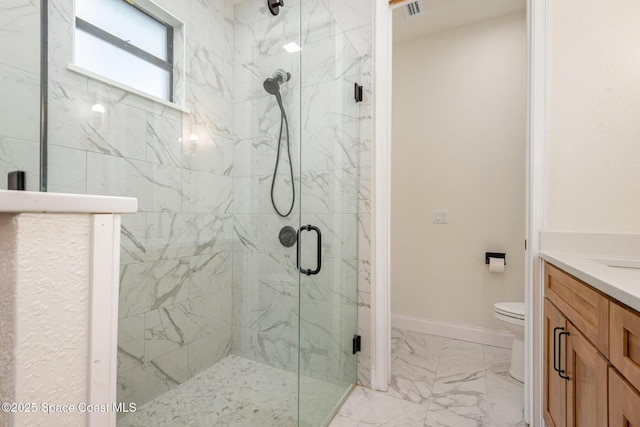 bathroom featuring vanity, toilet, and a shower with shower door