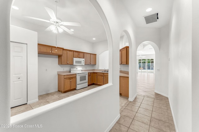 kitchen with white appliances, light tile patterned floors, ceiling fan, and sink