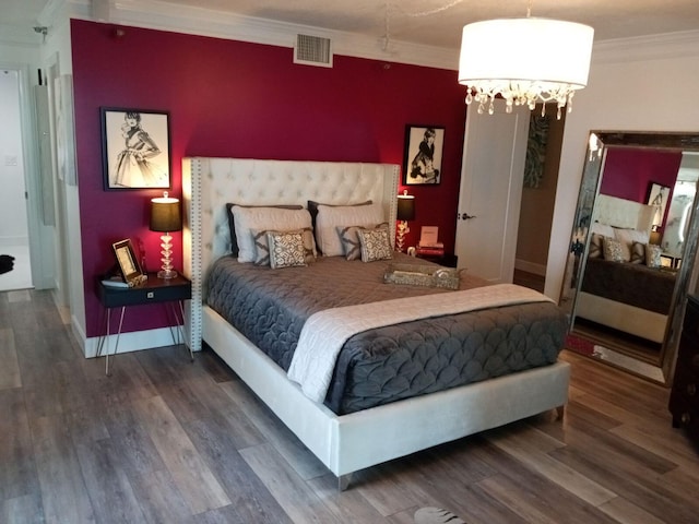 bedroom with crown molding, dark wood-type flooring, and a notable chandelier