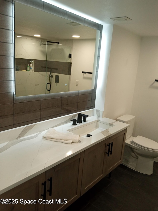 bathroom with vanity, toilet, an enclosed shower, and decorative backsplash