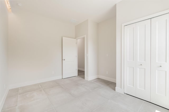 unfurnished bedroom with light tile patterned flooring and a closet