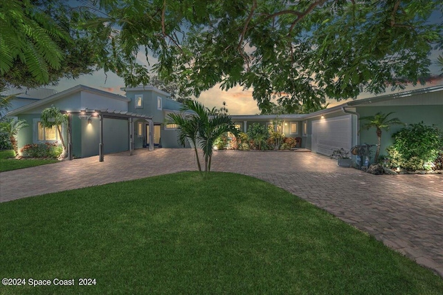 view of front of house with a front yard, decorative driveway, and an attached garage