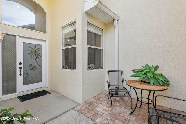 doorway to property featuring stucco siding and a patio