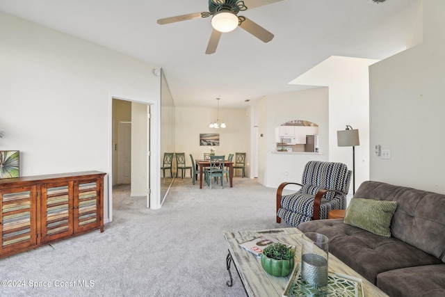 living area with ceiling fan with notable chandelier and light colored carpet