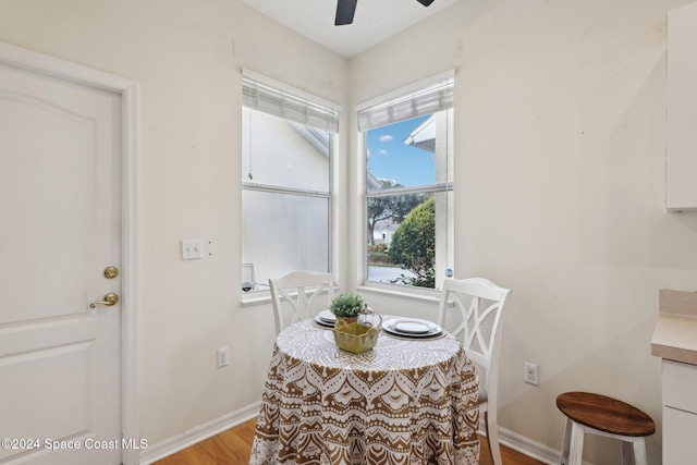 dining space with baseboards, a ceiling fan, and light wood-type flooring