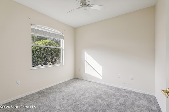 carpeted empty room featuring baseboards and ceiling fan