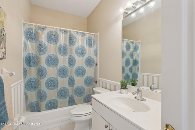 full bath featuring a wainscoted wall, vanity, shower / tub combo, and toilet