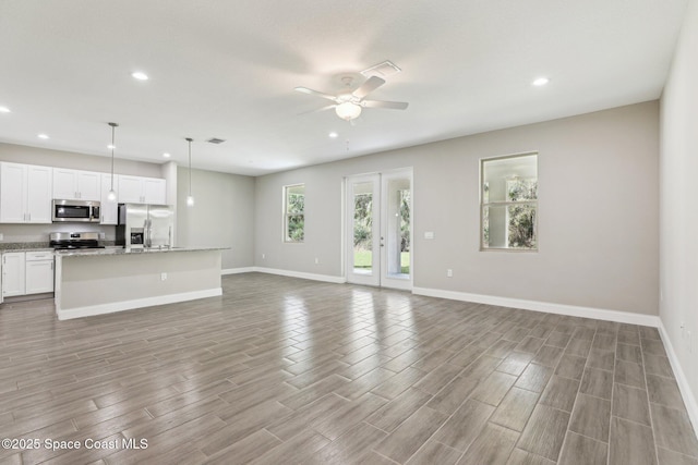 unfurnished living room featuring ceiling fan and light hardwood / wood-style flooring