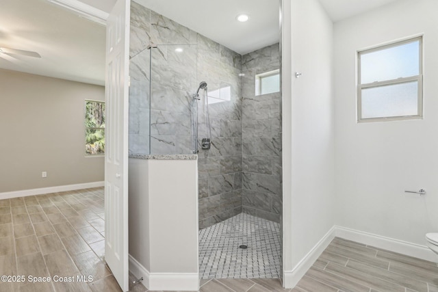 bathroom featuring toilet, a healthy amount of sunlight, and tiled shower