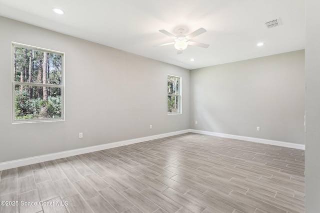 empty room with ceiling fan and light hardwood / wood-style floors