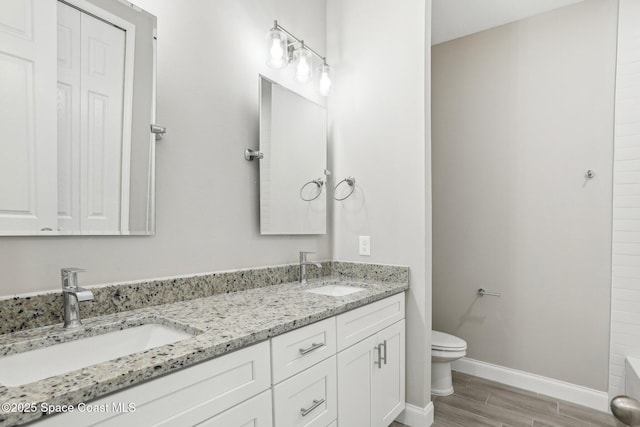 bathroom with hardwood / wood-style flooring, vanity, and toilet