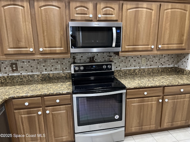 184 Tramore Pl, Melbourne Beach, FL 32951 - kitchen featuring light tile patterned flooring, appliances with stainless steel finishes, tasteful backsplash, and dark stone countertops