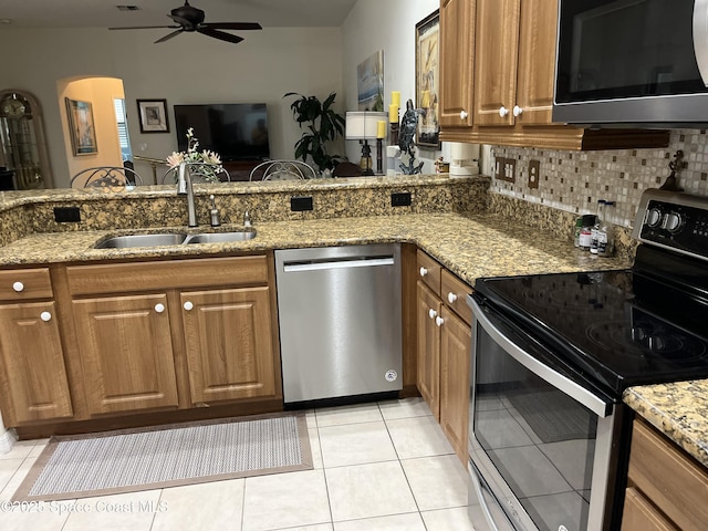 184 Tramore Pl, Melbourne Beach, FL 32951 - kitchen with brown cabinets, ceiling fan, appliances with stainless steel finishes, and a sink