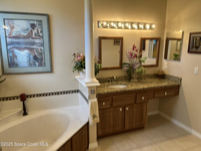 184 Tramore Pl, Melbourne Beach, FL 32951 - bathroom with a garden tub, baseboards, ornate columns, and vanity