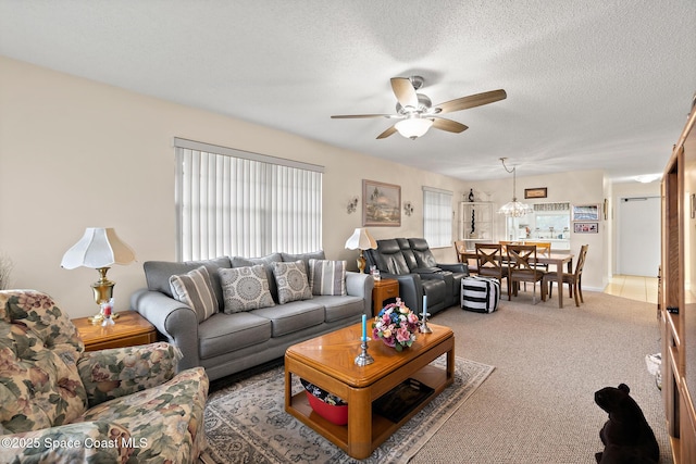 living room with a healthy amount of sunlight, a textured ceiling, a ceiling fan, and light colored carpet