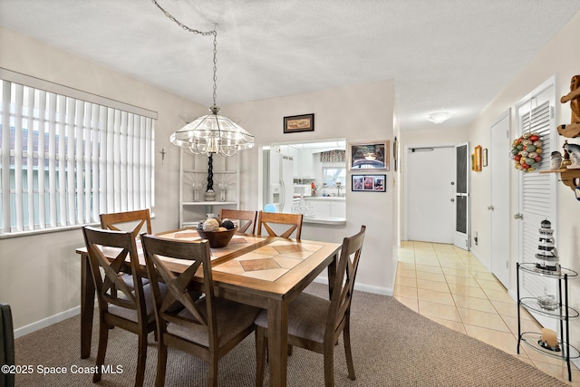 dining area featuring light carpet, baseboards, and light tile patterned floors