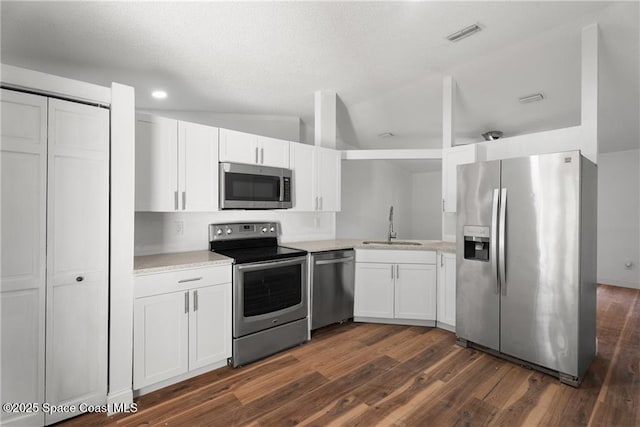 kitchen with sink, dark wood-type flooring, white cabinets, and appliances with stainless steel finishes