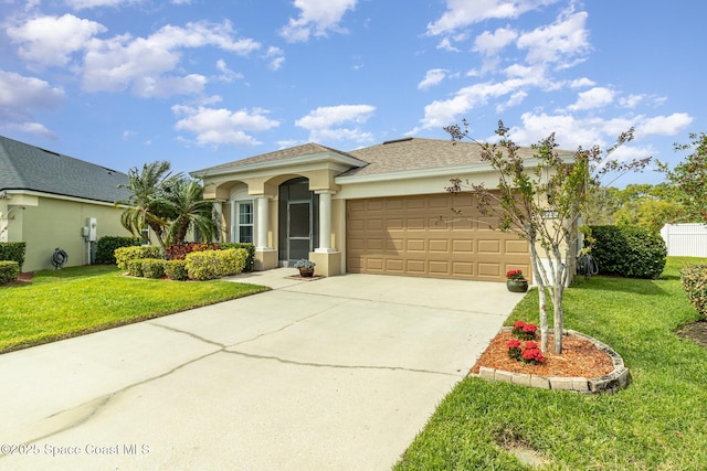 mediterranean / spanish home with stucco siding, a front lawn, concrete driveway, an attached garage, and a shingled roof