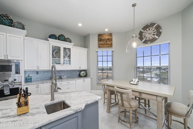 4955 Dixie Hwy NE Unit 801, Palm Bay, FL 32905 - kitchen featuring tasteful backsplash, white cabinets, stainless steel appliances, and a sink