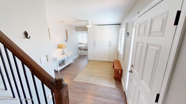 corridor with stairway, visible vents, light wood-type flooring, and baseboards