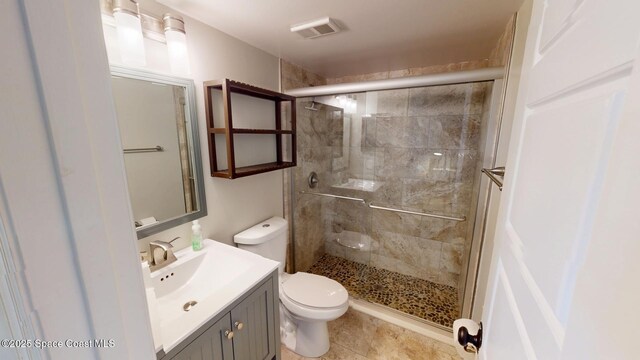 bathroom featuring visible vents, a stall shower, toilet, and vanity