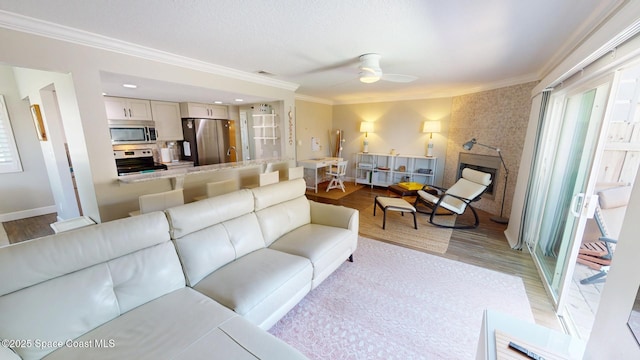 living area with light wood-style flooring, ornamental molding, and a fireplace