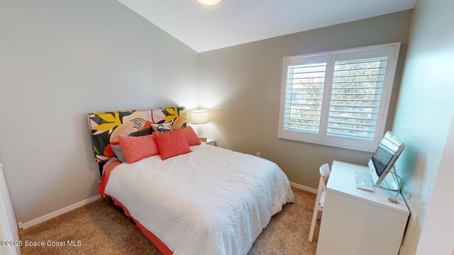 carpeted bedroom with baseboards and vaulted ceiling