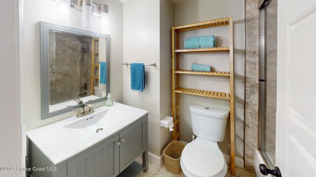 bathroom with baseboards, toilet, walk in shower, and vanity